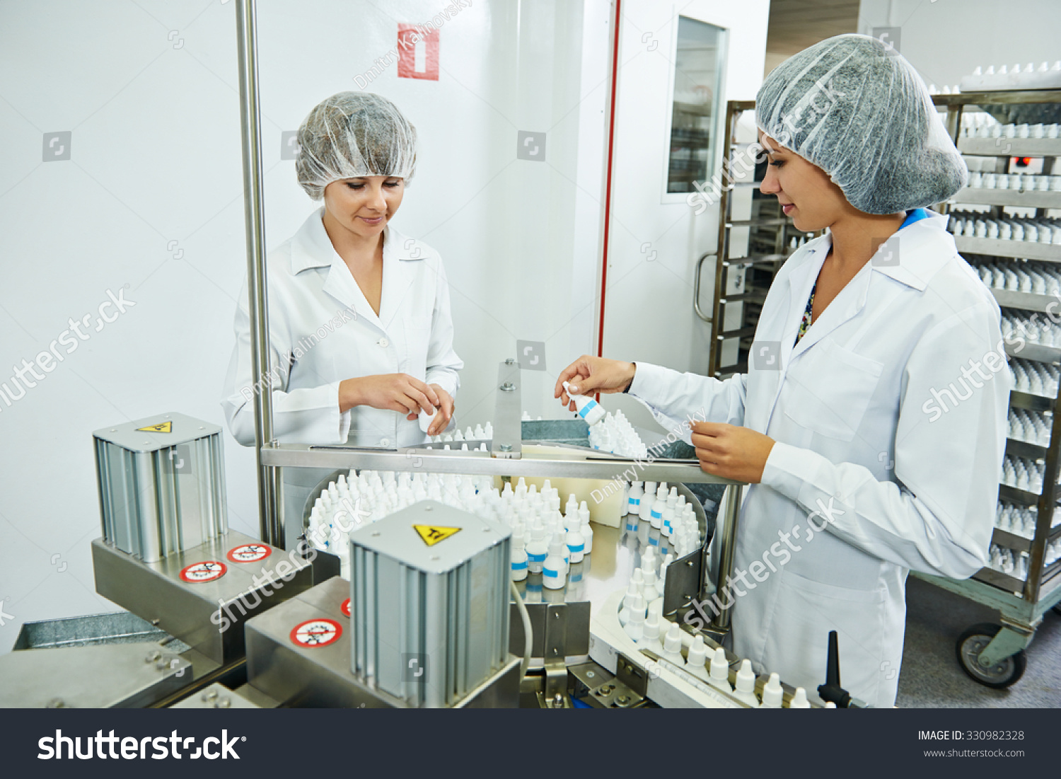 stock-photo-two-pharmaceutical-factory-workers-at-pharmacy-industry-manufacture-checking-medicine-on-conveyer-330982328